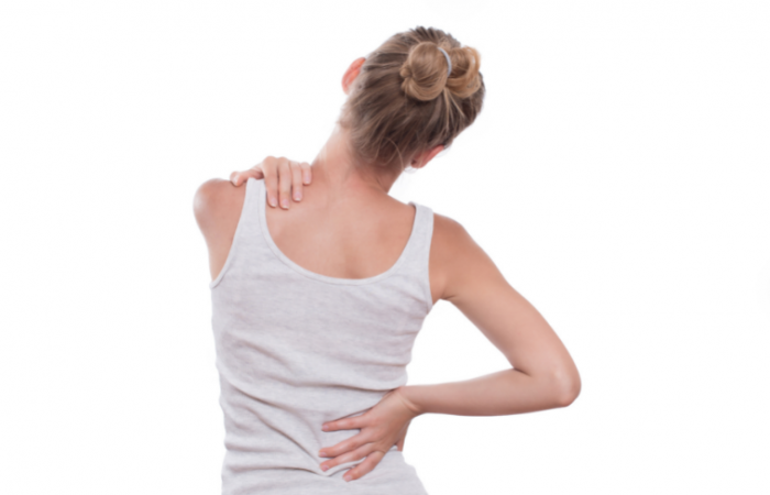 A woman holding her lower back in pain